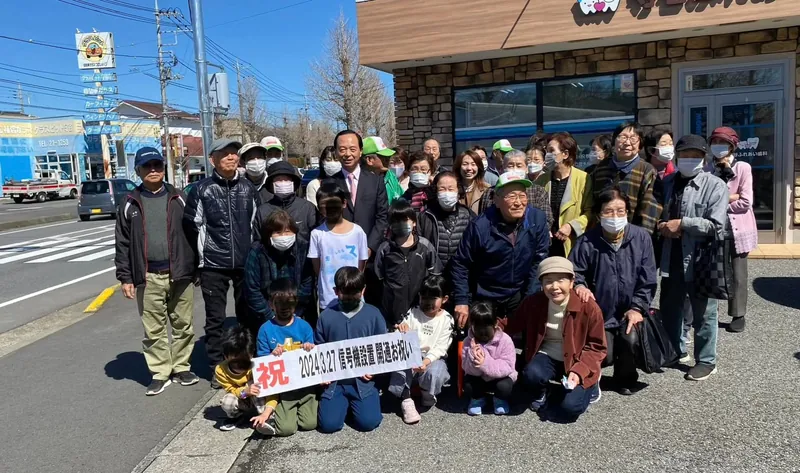 「祝 信号機設置」の横断幕を持って、地元の皆さんと