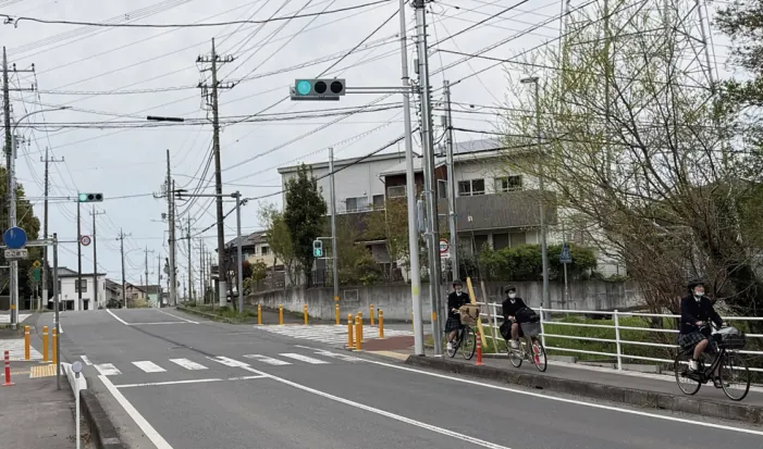 薬師台5丁目の交差点を自転車で渡る通学の生徒たち