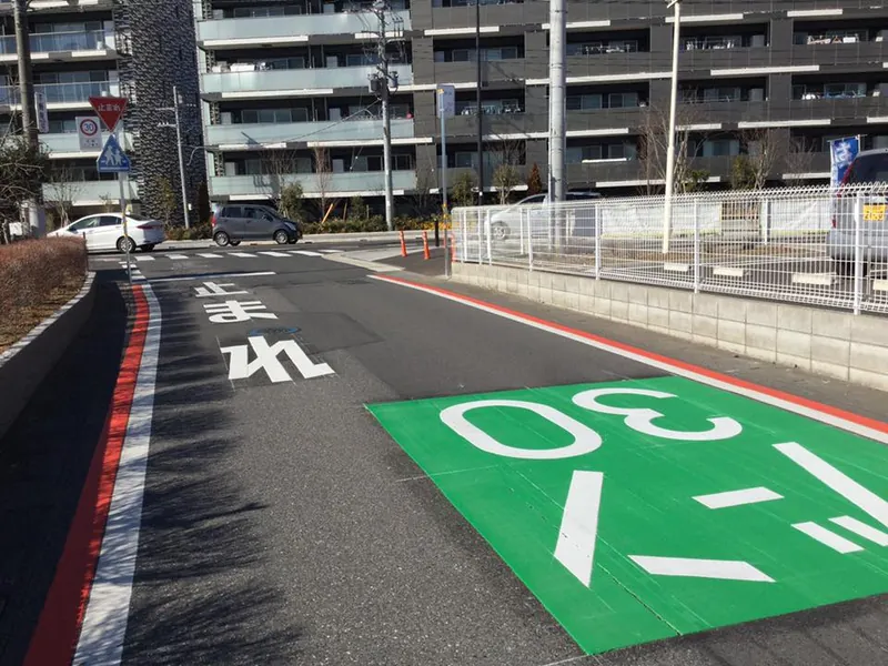 ひがし野地区の道路。路面に緑色で「ゾーン30」の表示