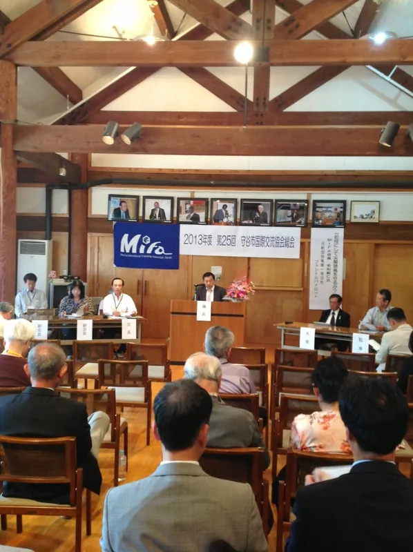 ログハースでの総会 正面の写真は歴代大使の講演